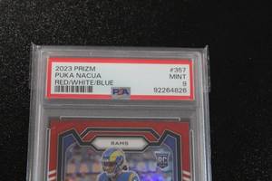 lot 17 image: 2023 Prizm Red White Blue Puka Nacua #357 PSA 9 Rookie Card