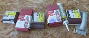 lot 198 image: New 4x36 inch sanding belts, caulk and a hand sander
