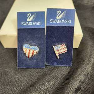 lot 140 image: Swarovski Pins Flag And Flag Heart Red White And Blue Swarovski Velvet Blue Bag Draw String