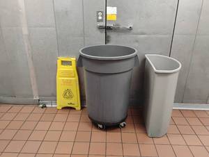lot 18 image: CAUTION SIGN, ROLLING TRASH CAN AND SLIM TRASH CAN