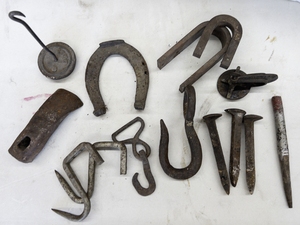 lot 141 image: Vintage ADZE head and an assortment of Metal Items (Horseshoe, rail spikes, hooks, Vintage tire clamp etc)