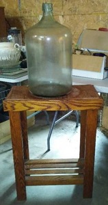 lot 560 image: 5 Gal Glass Bottle  And Wood Stand.