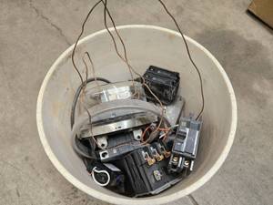 A bucket of electrical breakers and meter etc