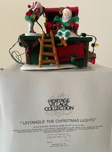 lot 48 image: Dept. 56 Heritage Village Series Untangle the Lights Porcelain, Lighted 1 of 2