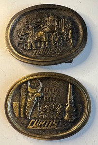 lot 203 image: Lot of 2 Curtis Machine Company Belt Buckles Dodge City