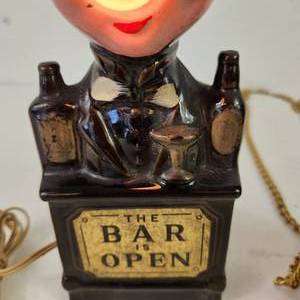 lot 33 image: Lot Of Two Bar Items 1950s Vtg The Bar Is Open Bartender Figurine Hanging Glass Work Is The Curse Without Drinking