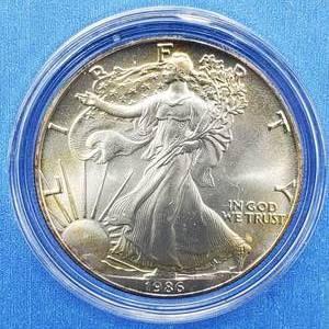 lot 38 image: 1986 American Silver Eagle in Airtite PLUS the Morgan Mint Wood Display Case for Silver Eagles.