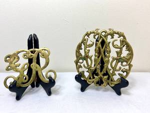 lot 35 image: Virginia Metalcrafters Colonial Willaimsburg Polished Brass Cypher Trivet 1950 and Vintage King George Brass Trivet