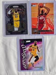 lot 296 image: Lot of 3 LeBron James 2022-23 Panini Magicians #1, 2021-22 Panini Prizm #91, 2009-10 Upper Deck #28
