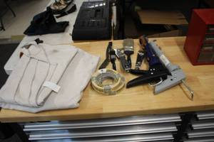 lot 1006 image: Lot of (11) Assorted Painting Tools - Drop Cloth, Scrapers, Caulk Guns, Tape, Brushes