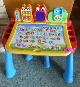 lot 44 image: Vtech activity desk and a bunch of plastic cups, bowls, silverware