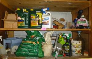 lot 230 image: Shelves full of lawn chemicals, hand crank seeders etc