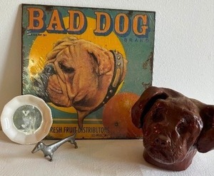 lot 352 image: Original Clay Art Dog Paperweight, Bad Dog Retro Tin, Husky Dog Ceramic Trivet Dish and Pewter Dachshund Figurine