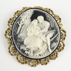 lot 145 image: Resin Black & Cream Cameo With Courting Couple Gold Tone Base Metal Brooch .