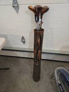 lot 552 image: Vintage Golf Clubs and Torn Leather Golf Bag