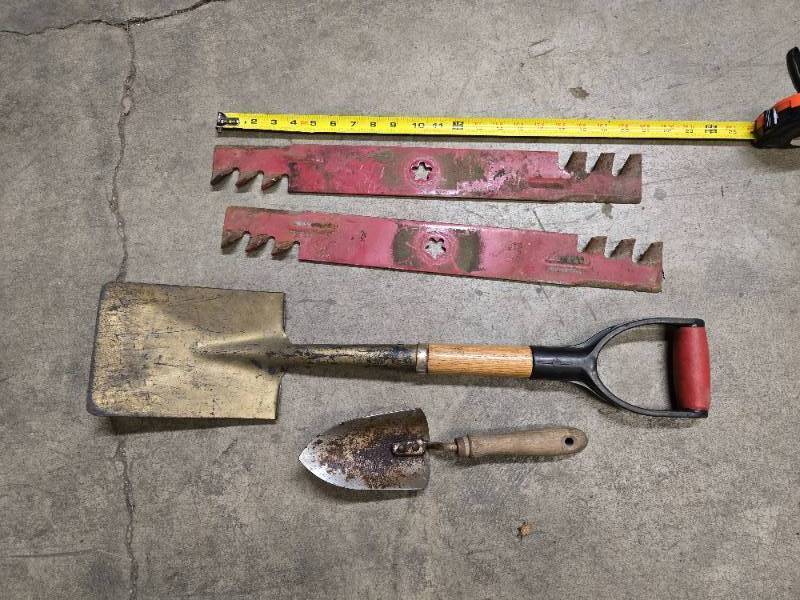 lot 64 image: 2 shovels (one small hand shovel and one 27 shovel) and 2 mulcher  mower blades (21) and a bucket of bungee straps  tie downs and ropes, 2 windshield brushes and 2 tire irons