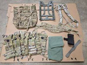 lot 29 image: OCPMulticam  Scorpion Large Rucksack complete (not assembled) - includes Bag, waist belt, frame & shoulder strap, 7 hydration pouches, 1 OD dirty bag, black clipboard for pilots knee, and 1 adjustable rigger belt