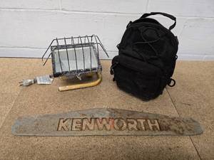 lot 17 image: Vintage metal Kenworth sign, portable light, and mini tool case with a variety of tools