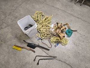 lot 39 image: a bucket of bungee straps  tie downs and ropes, 2 windshield brushes and 2 tire irons