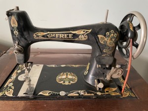 lot 2 image: Treadle Decorative Sewing Machine By Free.  Wonderful Wooden Cabinet and Machine Attachments