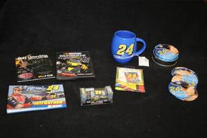 lot 1741 image: Lot of (7) #24 Jeff Gordon Collectibles - (2) DVDs, (1) 6-pc Coaster Set with Tin, (1) Matchbox Car, (1) Coffee Mug, (1) Photo album, (1) Flag 11x15