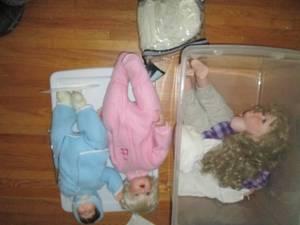 Trio of porcelain dolls in covered ...