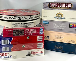 lot 53 image: Game & Puzzle Lot - 6 Puzzles, 3 Trivial Pursuit, 1 COLLECTOR EDITION of Vintage Wheels Game & Empire Builder Game