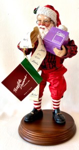 lot 120 image: CLOTHTIQUES by POSSIBLE DREAMS Collectable BACHMANS EXCLUSIVE The Best Things Come In Purple Packages Santa Figure with Box and Wooden Stand
