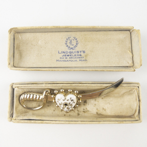 lot 230 image: Coro Sword And Enamel Heart Motif Yellow Base Metal Brooch . In Original Lindquist Jewelers Gift Box