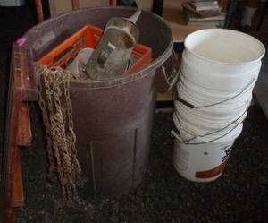 lot 163 image: garbage barrel with chains, funnel, crates, boat bumper and pile of pails