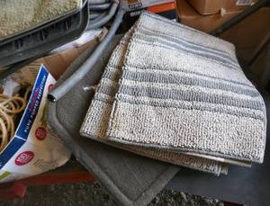 lot 220 image: multiple boxes of stuff - rugs, car mats, gas jug, brush, casters, auto parts