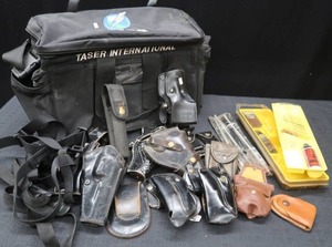 lot 100 image: TASER BAG-TASER INTERNATIONAL FILLED WITH HOLSTERS AND ACCESSORIES
