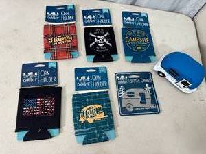 lot 145 image: New Camping Themed Can Coolers, Hitch Cover, and Magnetic Bottle Opener
