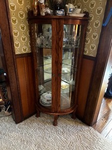 lot 88 image: Antique Corner Display Case With Curved Glass Doors And Mirrored Back And Feet Measuring 32 X 20 X 60. Contents Are Not Included.
