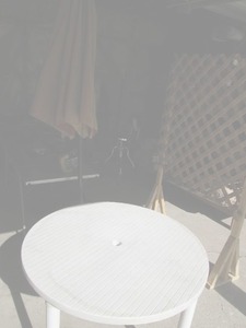 lot 37 image: Round plastic patio table with umbr...