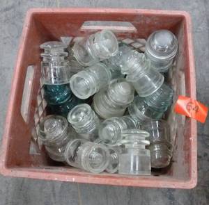 lot 64 image: milk crate of glass insulators