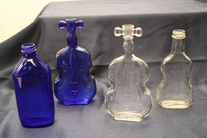 lot 100 image: Set of 4 Vintage Musical Instrument-Shaped Glass Bottles