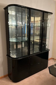 lot 10 image: Sleek Black and Curved Glass Cabinet with Mirrored Back and Glass Shelves