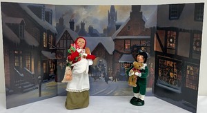 lot 186A image: Byers Choice Ltd - The Carolers - Woman with Christmas Dinner Groceries, Boy with Teddy Bear (2000) and City Backdrop