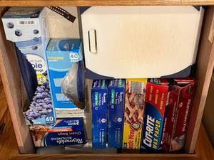 lot 443 image: Assortment of Kitchen Packaging Supplies - Aluminum Foil, Plastic Wrap, Wax Paper, Oven Bags & Cutting Board