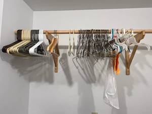 lot 418 image: Assortment of Hangers and Vintage Wooden Hanger w Floral Design & Suspenders & Belt