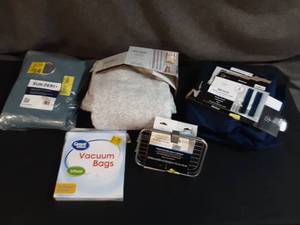 lot 25 image: Cream Shower Curtain, SunZero Blue Curtain, Blue Mainstay Curtain, Vacuum Bags, And Metal Soap Holder