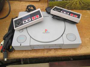 lot 12 image: Original Sony Playstation with 2 co...