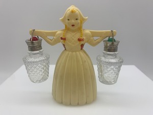 lot 33 image: Vintage Plastic Dutch Girl Carrying a Set of Salt and Pepper Glass Shakers
