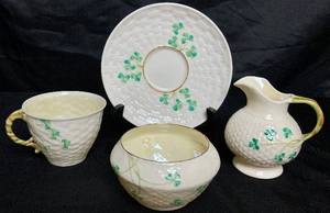 lot 117 image: Irish Belleek Porcelain Classic Shamrock Tea Cup, Saucer, Sugar Dish and Creamer Pitcher