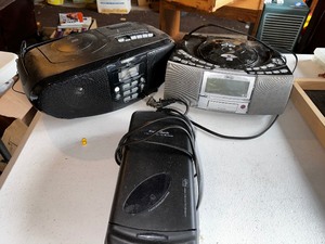 lot 962 image: Wedge SD CardCD Player Radio Alarm Clock, Radio Shack VHS Video Cassette Rewinder, and Portable Boombox