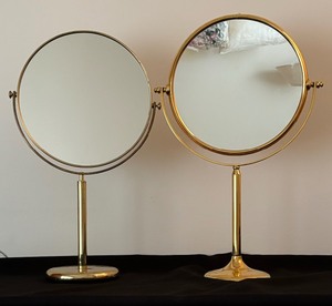 lot 31 image: Two Standing Brass Coloring Magnified Vanity Mirrors