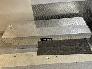 lot 51 image: Husky 71.36 in. Diamond Plate Aluminum Full Size Crossbed Truck Tool Box - Retail $415 - Missing Keys - Minor Scuffs  Dents