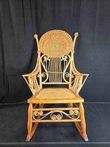 lot 11 image: Vintage Wicker Rocking Chair with Intricate Detailing