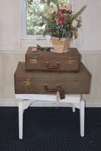 lot 66 image: Swivel-Top Wood Table, Antique Satin-Lined Suitcase Set w Custom Floral Arrangement